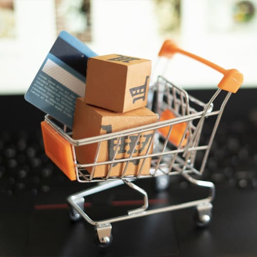 tiny shopping cart with boxes and credit card inside