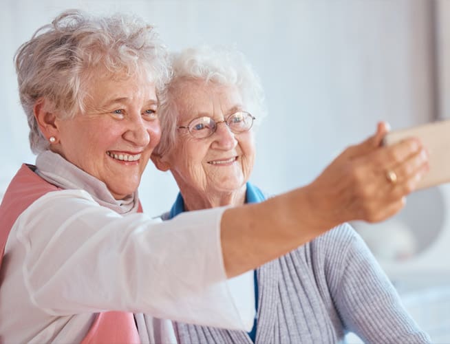 two senior women taking a selfie with cell phone