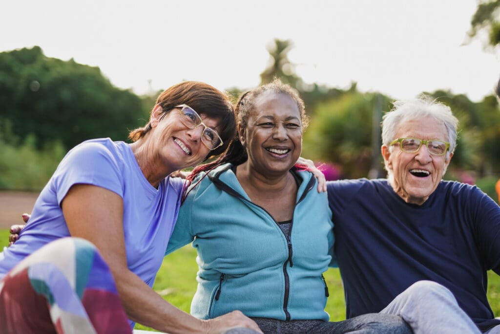 Happy seniors sitting outside having fun at senior living community