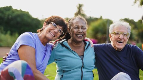 Happy seniors sitting outside having fun at senior living community